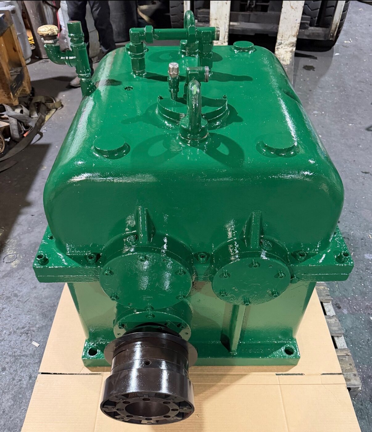 A rebuilt green gearbox with a new output coupling, front view