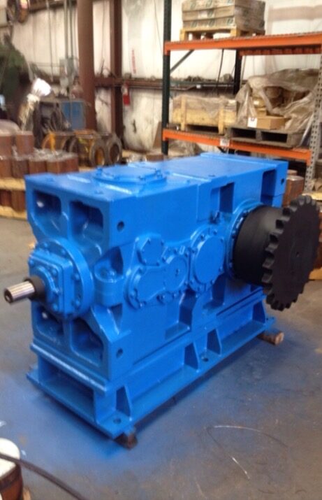 A rebuilt blue gearbox with a sprocket fitted, in the shop