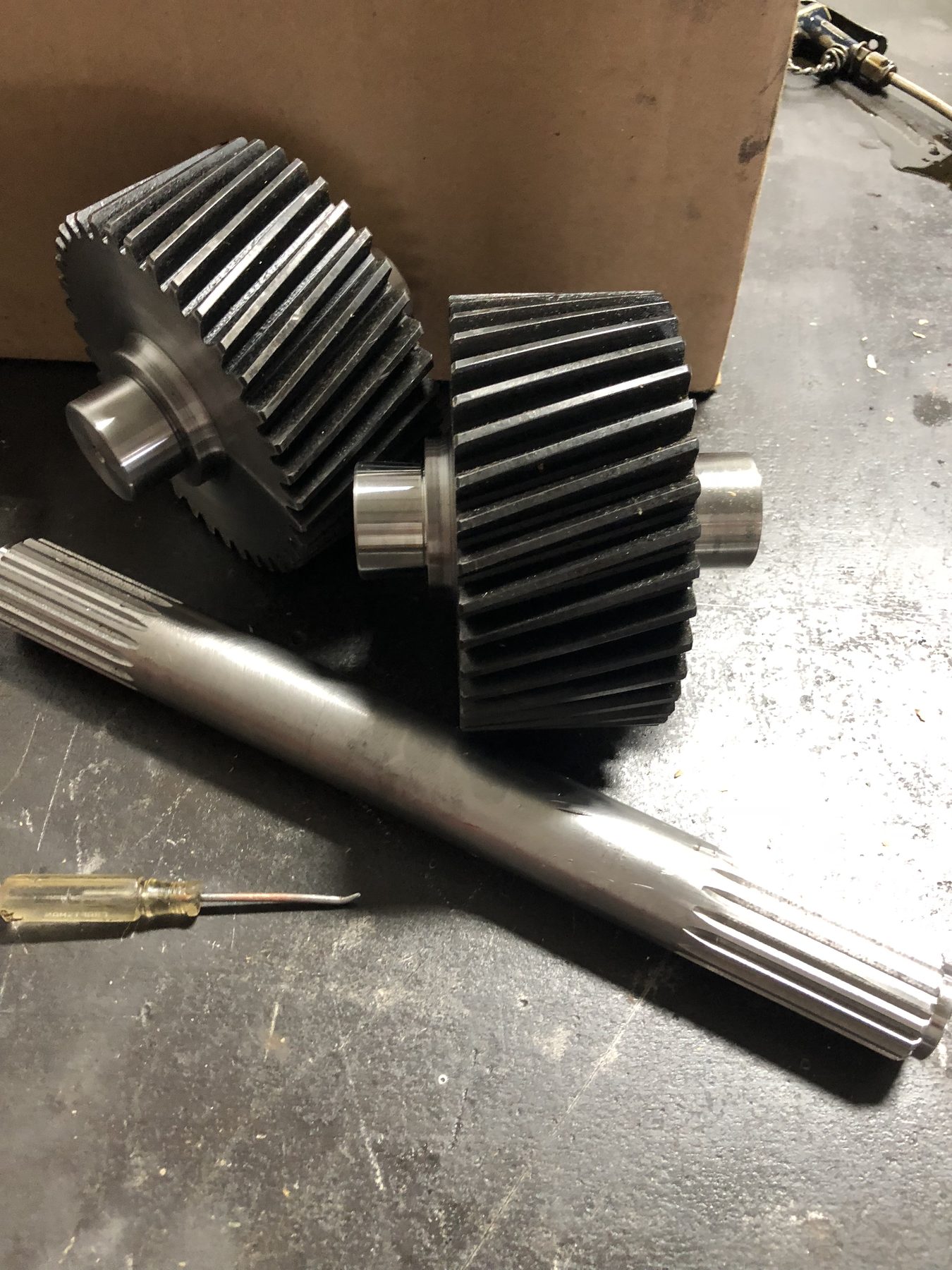 Two rebuilt helical gears and a splined drive shaft after machining