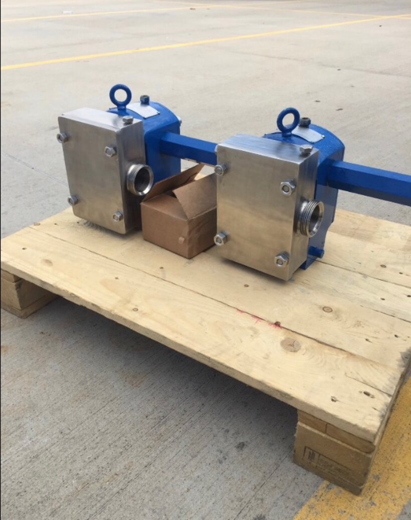 Two stainless steel positive displacement pumps rebuilt by Solution Gear Co. in Houston, TX, mounted on a shaft and ready to return to service
