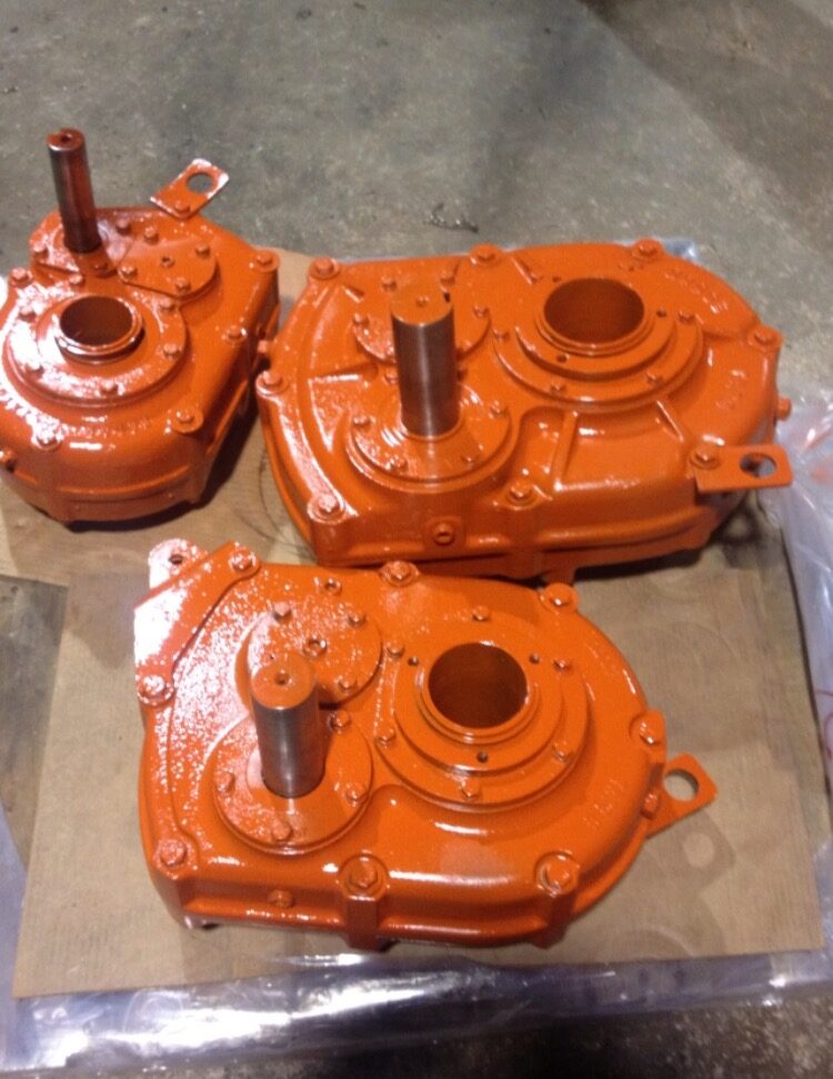 Three rebuilt orange shaft mounted gear drives on a pallet